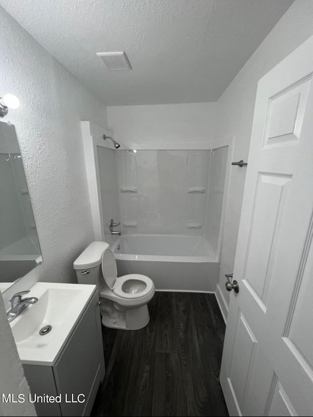 128 Carolyn Ave, Jackson, MS 39209 - bathroom featuring a textured ceiling, wood finished floors, a textured wall, tub / shower combination, and toilet