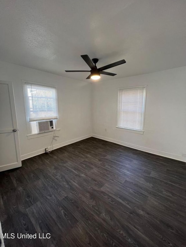 empty room featuring cooling unit, dark wood-type flooring, and ceiling fan