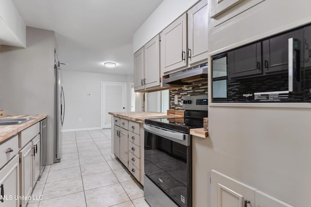 120 Clower Ave, Long Beach, MS 39560 - kitchen with stainless steel appliances, under cabinet range hood, wooden counters, tasteful backsplash, and light tile patterned floors