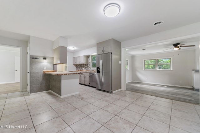 120 Clower Ave, Long Beach, MS 39560 - kitchen featuring stainless steel appliances, a peninsula, gray cabinets, light tile patterned flooring, and a ceiling fan