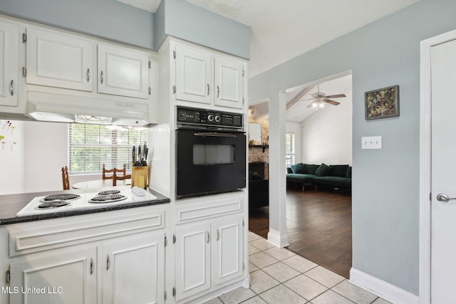 kitchen featuring oven, ceiling fan, under cabinet range hood, white electric cooktop, and light tile patterned floors
