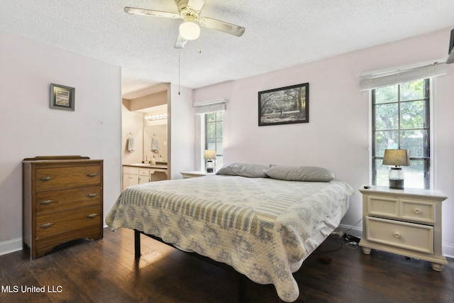 bedroom with dark wood-style flooring, a textured ceiling, and multiple windows