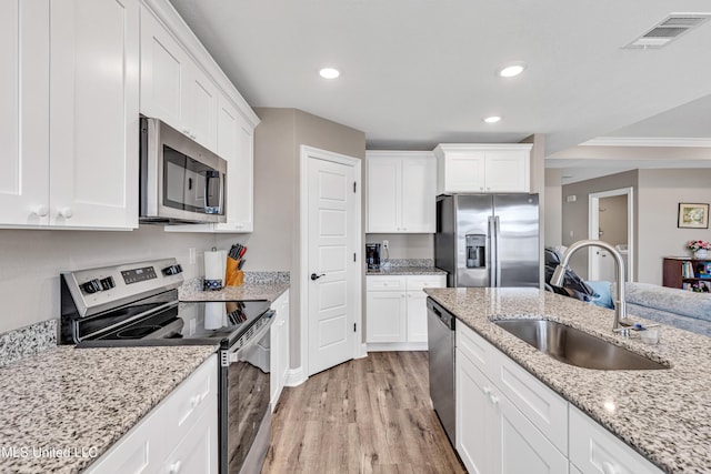 kitchen featuring light wood-type flooring, stainless steel appliances, sink, and white cabinets