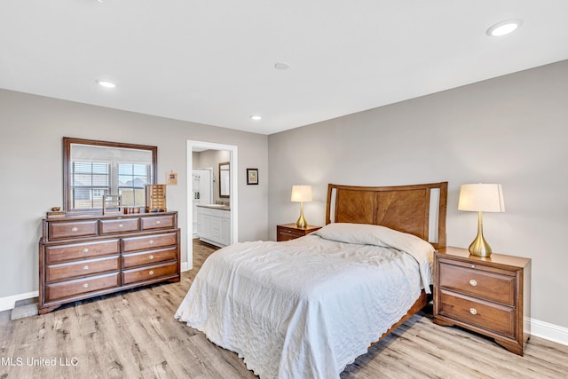 bedroom with ensuite bathroom and light wood-type flooring