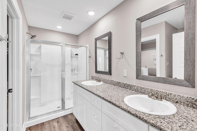 bathroom featuring vanity, hardwood / wood-style floors, and a shower with door