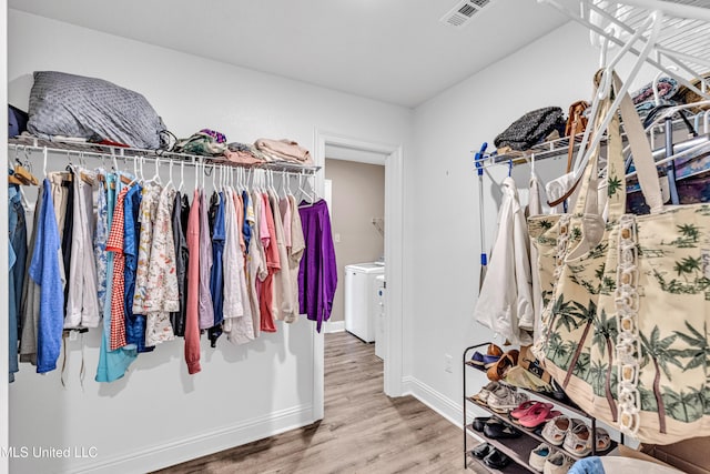 walk in closet featuring washer / dryer and hardwood / wood-style floors