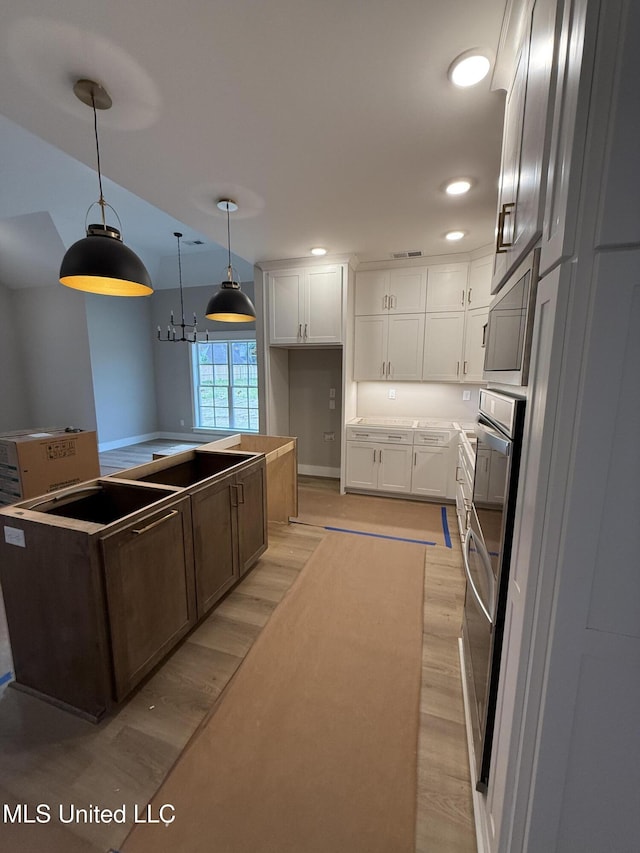 4263 S Bolivar Trl, Olive Branch, MS 38654 - kitchen featuring light wood-style floors, white cabinets, hanging light fixtures, a kitchen island, and recessed lighting