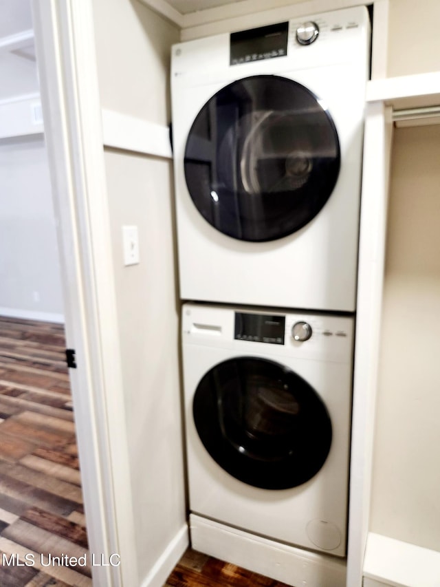 washroom featuring stacked washing maching and dryer and dark hardwood / wood-style floors