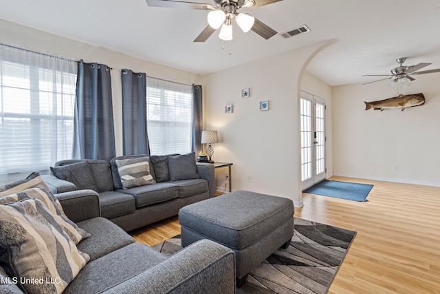 living room featuring french doors, ceiling fan, plenty of natural light, and light wood-type flooring