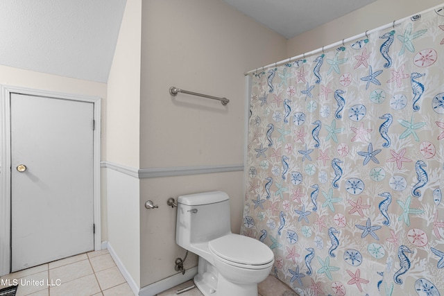 bathroom with toilet, tile patterned floors, and a shower with curtain