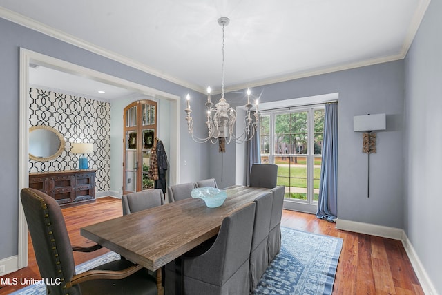 dining space featuring hardwood / wood-style flooring, a chandelier, and crown molding