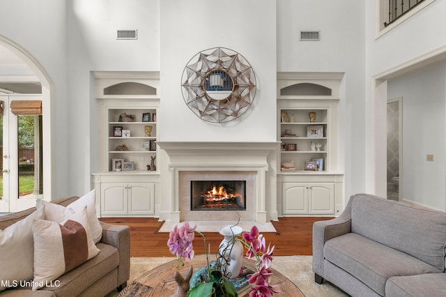 living room featuring a high ceiling and light wood-type flooring