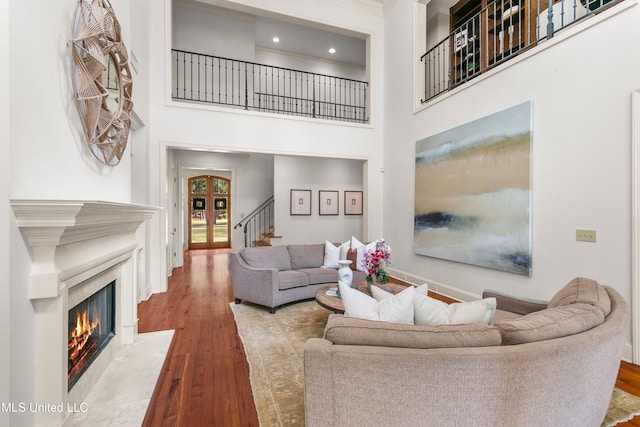 living room with a towering ceiling and light wood-type flooring