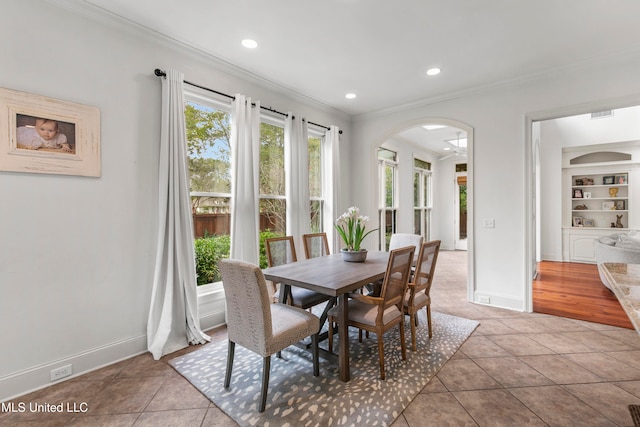 dining space featuring ornamental molding, built in features, and light tile patterned flooring