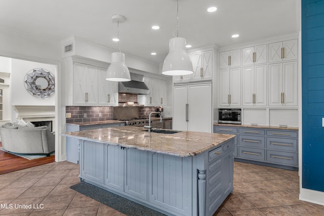 kitchen featuring white cabinetry, sink, decorative light fixtures, and paneled fridge