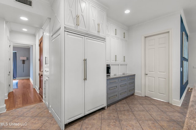 kitchen featuring white cabinetry, tile patterned floors, gray cabinetry, and ornamental molding