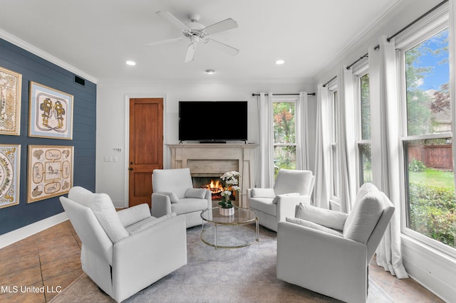 living room featuring ornamental molding, tile patterned flooring, and ceiling fan