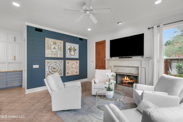 tiled living room featuring ceiling fan, a high end fireplace, and ornamental molding