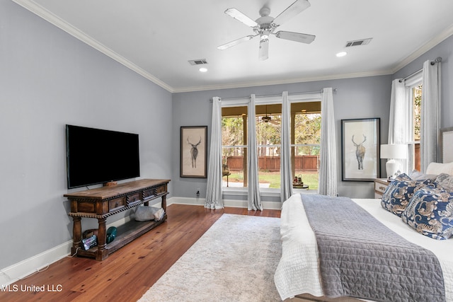 bedroom featuring ornamental molding, dark hardwood / wood-style flooring, multiple windows, and ceiling fan