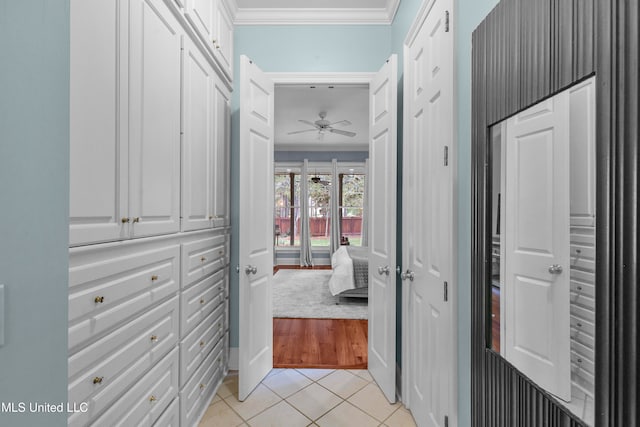 corridor featuring light tile patterned floors and crown molding