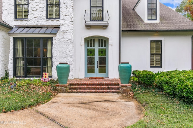 doorway to property featuring a balcony and french doors