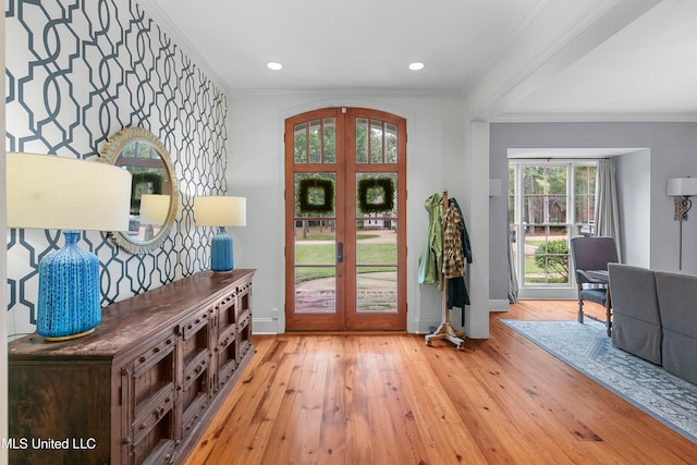 entrance foyer featuring light wood-type flooring, french doors, and ornamental molding