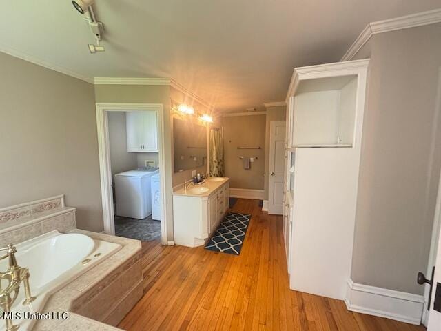 751 S Main St, Grenada, MS 38901 - full bath with vanity, a garden tub, washer and dryer, wood finished floors, and ornamental molding