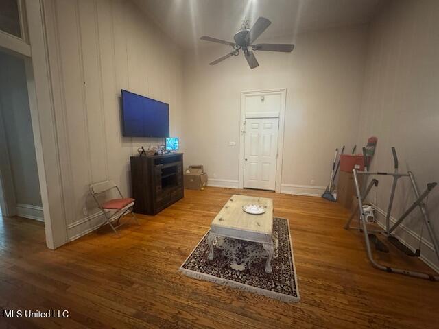 751 S Main St, Grenada, MS 38901 - living room featuring wood finished floors, a ceiling fan, baseboards, and a towering ceiling