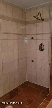 bathroom featuring tiled shower and tile patterned floors