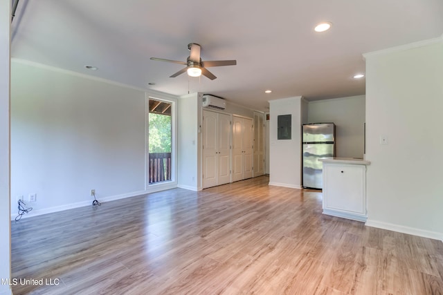 unfurnished living room featuring crown molding, electric panel, light hardwood / wood-style flooring, and a wall unit AC