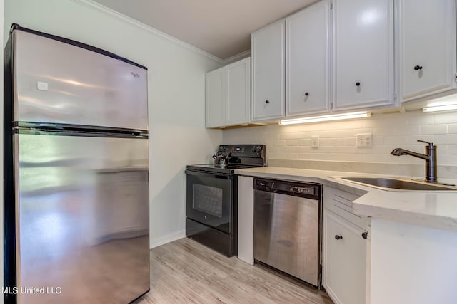229 Lakeside Villa Unit E, Diamondhead, MS 39525 - kitchen featuring crown molding, white cabinetry, tasteful backsplash, a sink, and appliances with stainless steel finishes