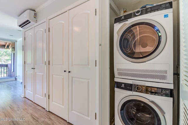 laundry room with crown molding, light hardwood / wood-style flooring, stacked washer and clothes dryer, and a wall mounted air conditioner