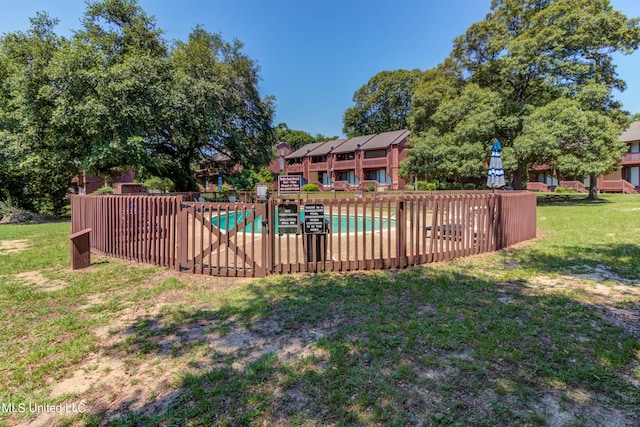 view of pool with a yard