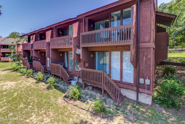 exterior space with a lawn and a balcony