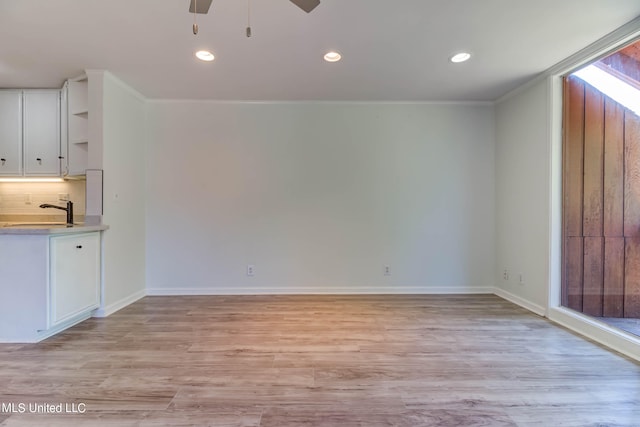 interior space featuring white cabinetry, sink, and light wood-type flooring