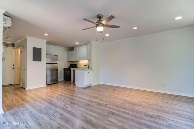 unfurnished living room with electric panel, ceiling fan, light hardwood / wood-style flooring, crown molding, and sink