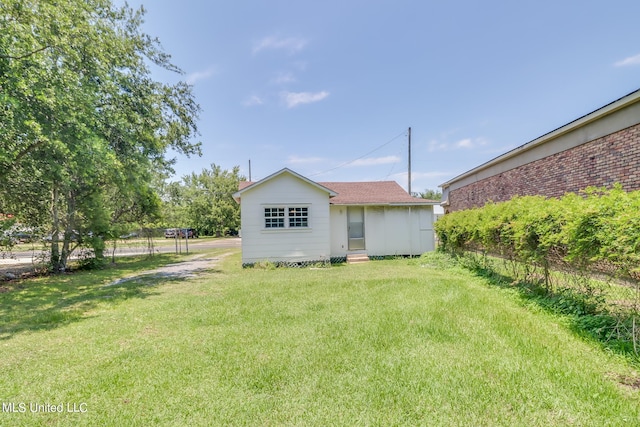 rear view of property featuring a yard