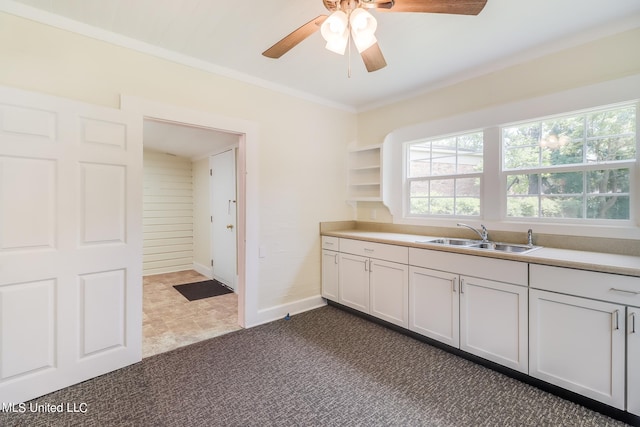 kitchen with white cabinetry, ceiling fan, sink, and dark carpet