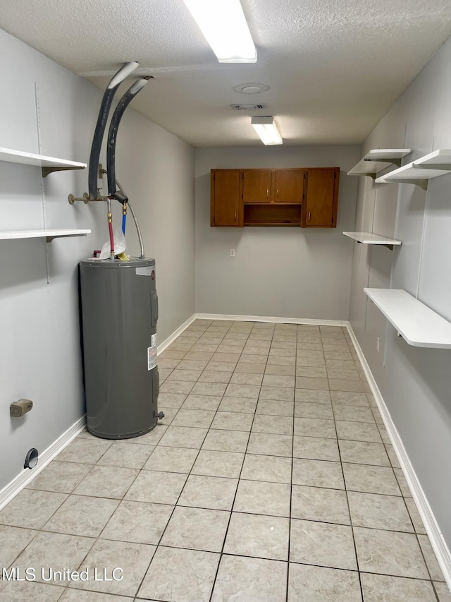 finished basement featuring light tile patterned floors, baseboards, a textured ceiling, and water heater