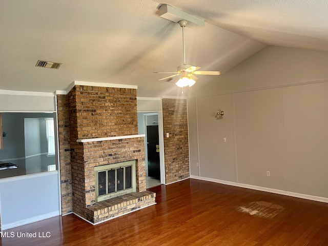 unfurnished living room featuring wood finished floors, a ceiling fan, visible vents, and a textured ceiling