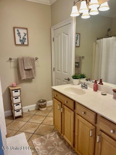 bathroom featuring a notable chandelier, crown molding, vanity, baseboards, and tile patterned floors