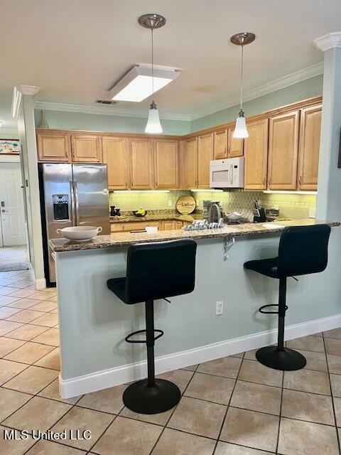 kitchen featuring light tile patterned flooring, crown molding, stainless steel refrigerator with ice dispenser, and white microwave