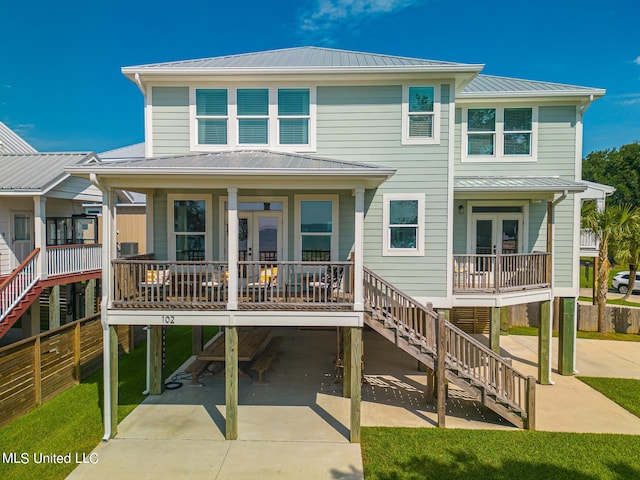 rear view of property featuring a porch, a yard, and a carport