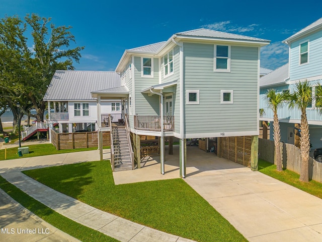 raised beach house with a front lawn and a carport