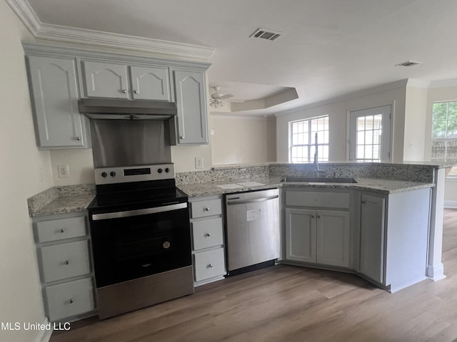 1620 Porpoise St, Ocean Springs, MS 39564 - kitchen with stainless steel appliances, a sink, under cabinet range hood, a peninsula, and crown molding