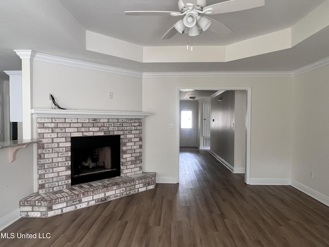 1620 Porpoise St, Ocean Springs, MS 39564 - unfurnished living room featuring a ceiling fan, a brick fireplace, wood finished floors, a raised ceiling, and baseboards