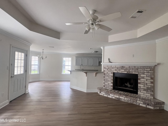 1620 Porpoise St, Ocean Springs, MS 39564 - unfurnished living room with ornamental molding, a tray ceiling, wood finished floors, a sink, and baseboards