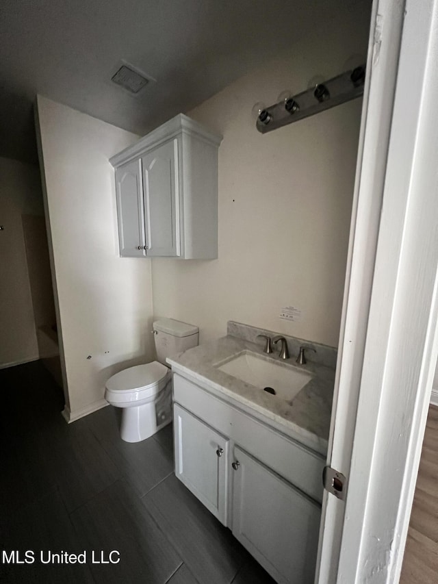 1620 Porpoise St, Ocean Springs, MS 39564 - bathroom with toilet, vanity, and wood finished floors