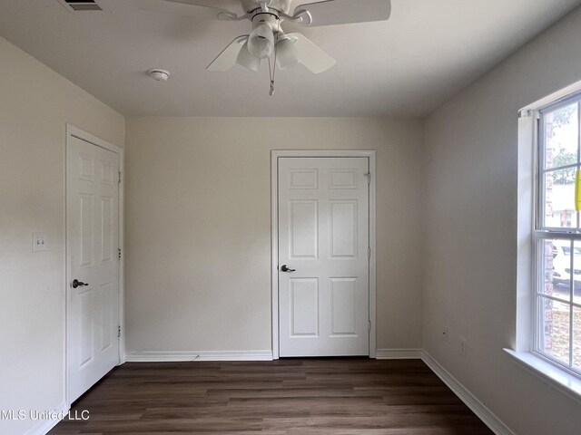 1620 Porpoise St, Ocean Springs, MS 39564 - unfurnished bedroom with baseboards, dark wood-type flooring, and ceiling fan