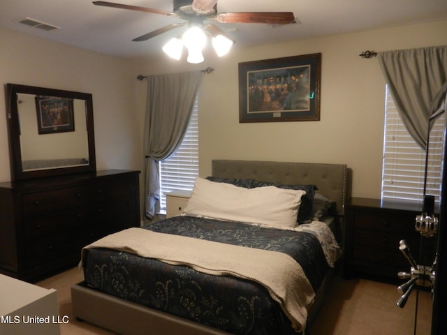 carpeted bedroom featuring ceiling fan and visible vents